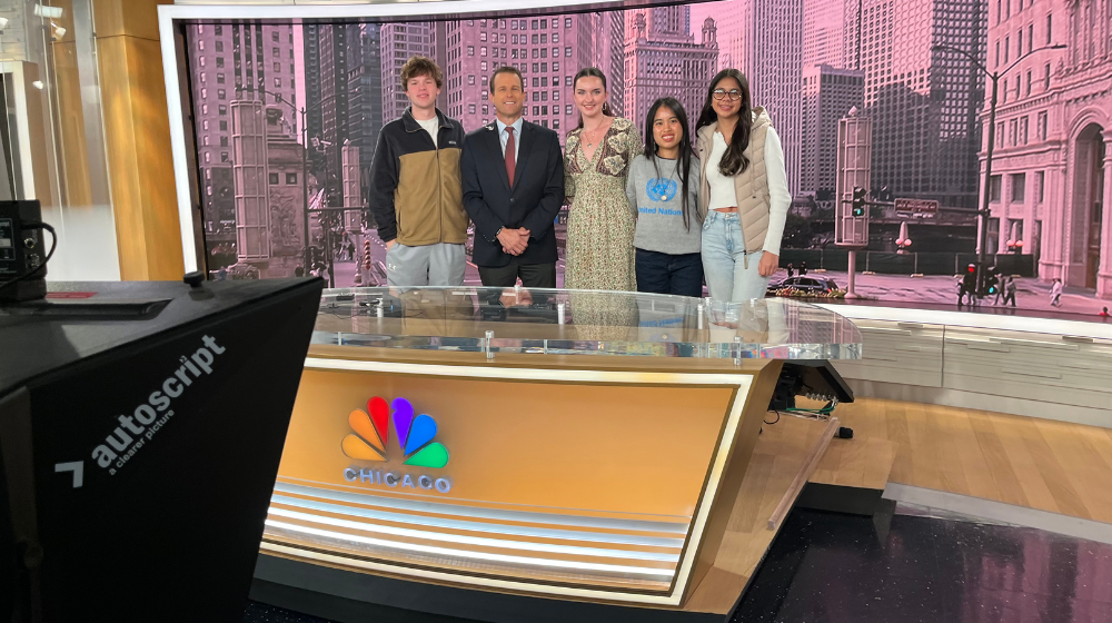 LUC students huddle together inside a local news station