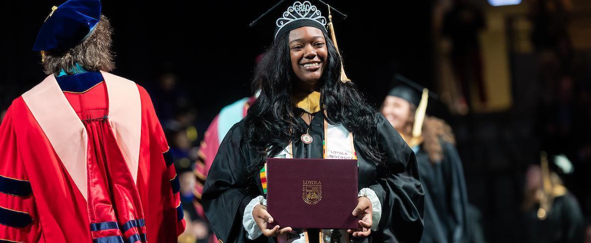 An MSW graduate receives their diploma during the 2025 Commencement ceremony