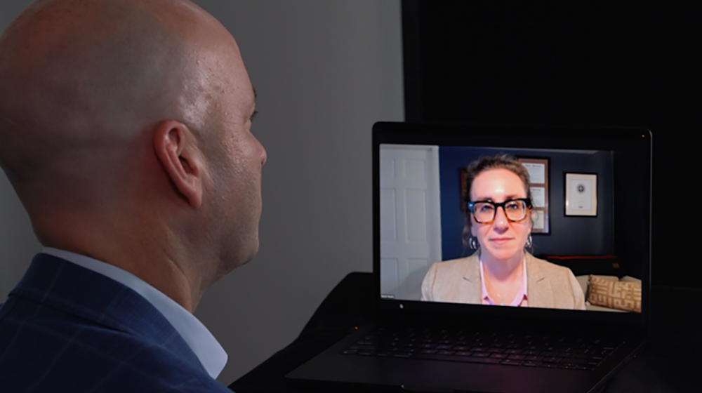 Man participating in a video call on a laptop with a woman on screen