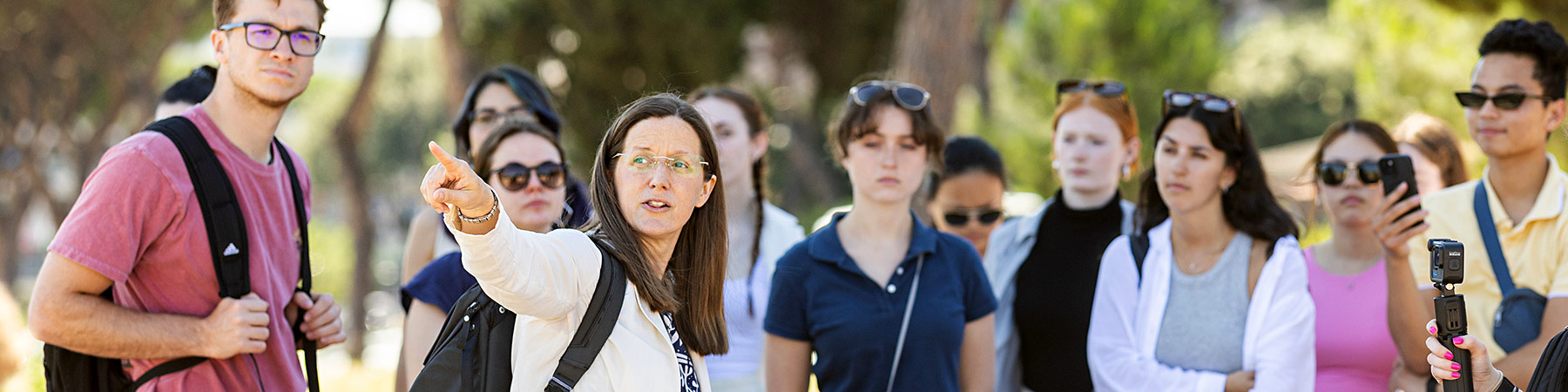 An instructor at the John Felice Rome Center speaks to a large group of students outdoors.