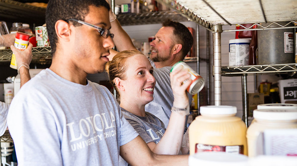 People organizing food supplies on shelves in a pantry or kitchen.