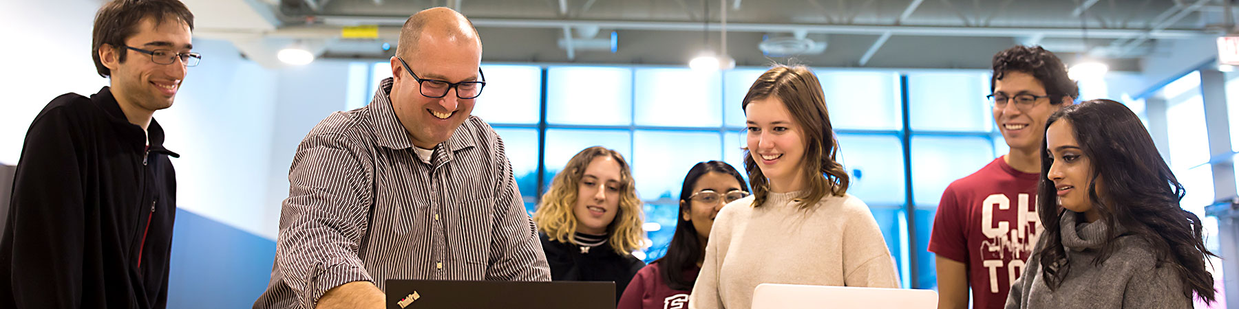 An instructor interacts with students in a classroom setting