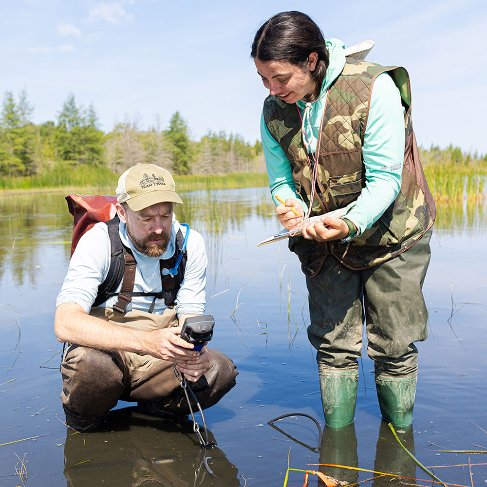 A Loyola University Chicago professor works alongside a student in the field gather research material.