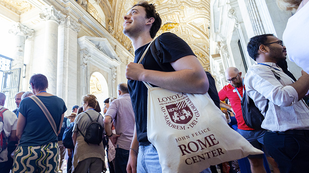 A students walks in a museum with a John Felice Rome Center bag