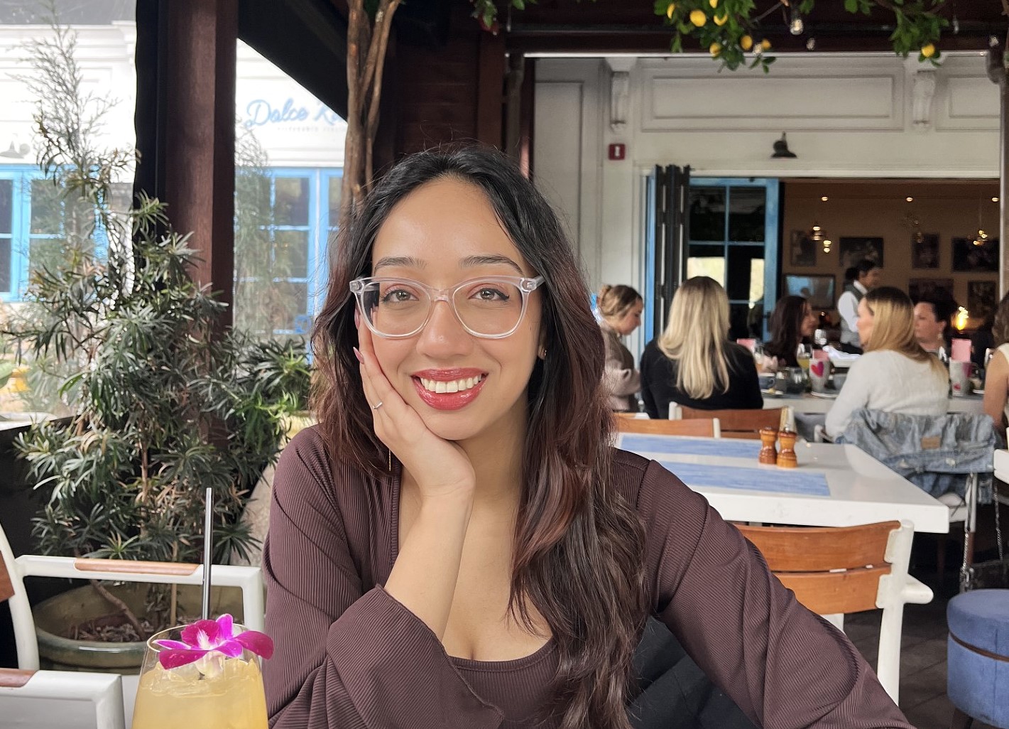 Young woman with dark hair, smiling in a restaurant